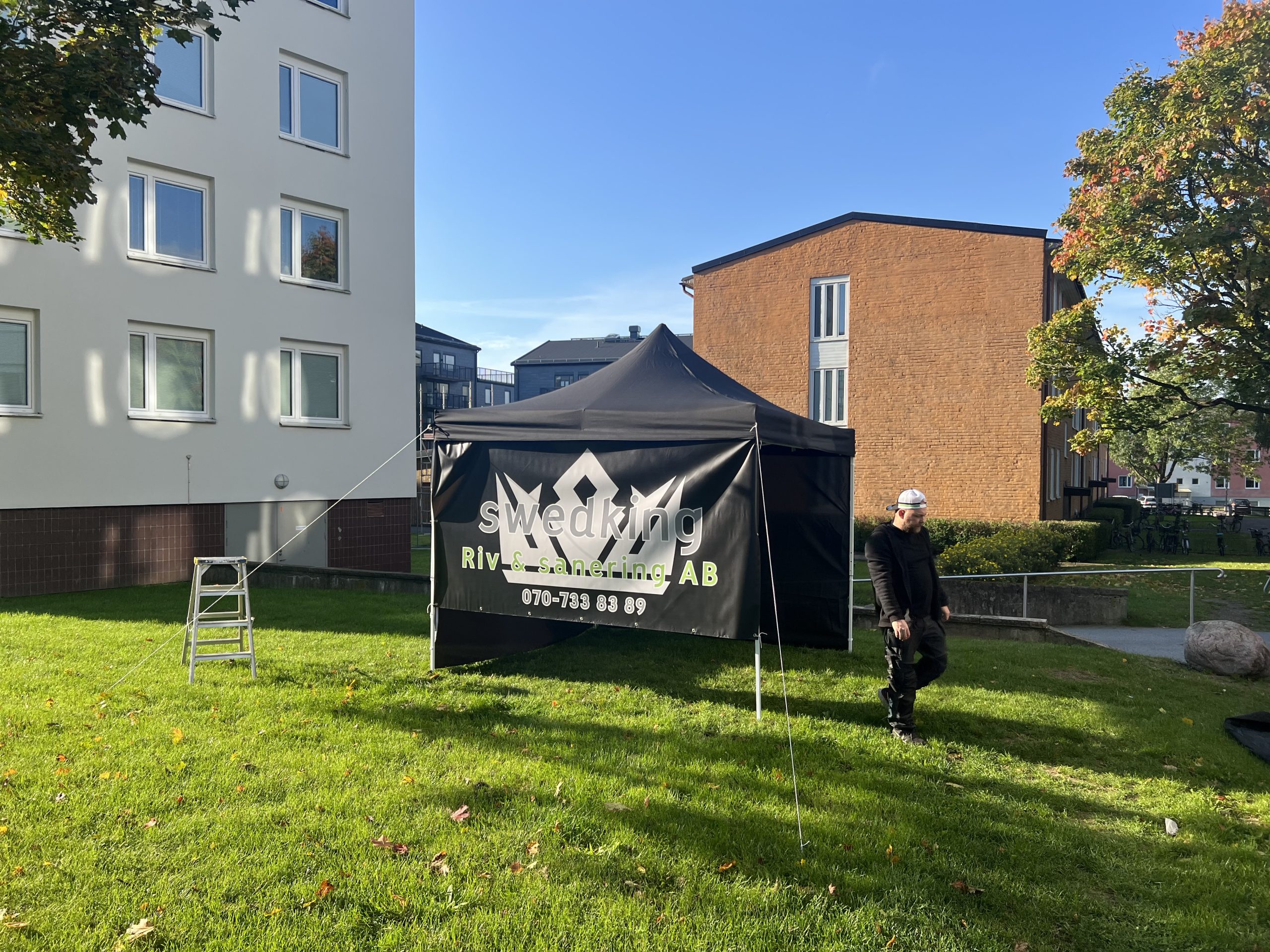 Swedking riv och sanering AB har satt upp ett tält på en gräsmatta som marknadsföring för företaget som asbetsanering uppsala.